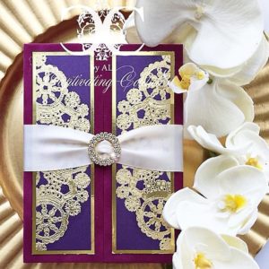 A Quinceanera flower Hair Accessory with a purple and gold Quinceanera invitation on a gold plate