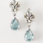 A pair of Quinceanera earrings featuring blue stones