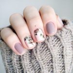 A Quinceanera-themed image featuring nail designs. The image showcases a person with a pink manicure holding a knitted glove.