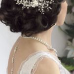 A close up of a woman wearing a Quinceanera hair comb and jewellery hairstyle.