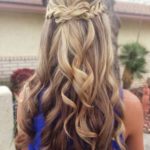 A woman with long blonde hair and a blue dress, showcasing a Quinceanera hairstyle