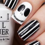 Quinceanera-themed nail art featuring a black and white manicure, with a person holding a bottle of nail polish