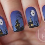 A person holding a black and orange manicure with nail designs inspired by Quinceanera decorations and the colors of a jack o' lantern.