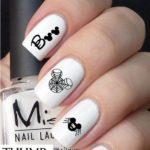 A picture of a person with white manicured nails holding a bottle of Quinceanera themed nail polish