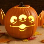 Quinceanera-themed image of a group of pumpkins with faces carved into them, resembling Disney characters