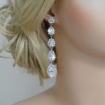 A close up of a woman wearing a pair of Quinceanera earrings