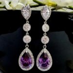 A pair of purple and white diamond earrings for a Quinceanera
