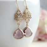 A close up of a pair of Quinceanera earrings on a cup