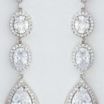 A pair of diamond earrings on a white background, perfect for a Quinceanera