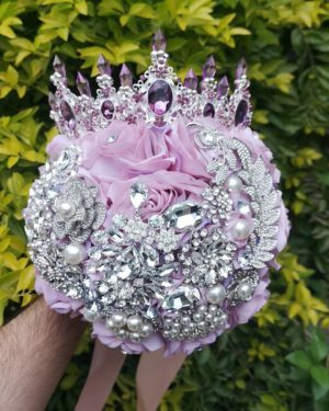 Quinceanera image of a person holding a bouquet of lilac flowers with a crown on it