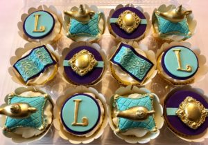 A turquoise tray of cupcakes with gold and blue decorations for a Quinceanera on Etsy.