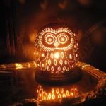 A lit owl sitting on top of a table with Quinceanera lighting