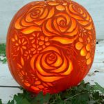 Quinceanera theme: A carved pumpkin sitting on top of a wooden table