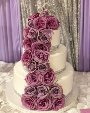 Quinceanera cake, a cake decorated with purple roses and a tiable