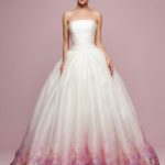 A woman in a white and pink gown by Daalarna Kft. for a Quinceanera celebration