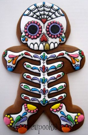 Quinceanera themed gingerbread house, decorated with a skeleton on it, resembling the dia de los muertos gingerbread man