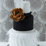 Quinceanera cake, a black and white fondant cake with a flower on top