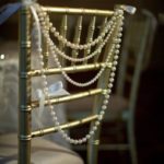 Quinceanera decor ideas featuring pearls. Close up of a chair adorned with pearls.