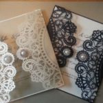 A close up of two Quinceanera invitations with lace on them