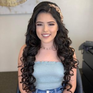 Quinceanera: Long hair woman sitting in a chair with ondas suelto peinados para 15 años
