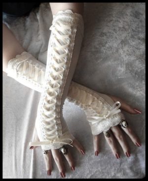 A woman wearing a corset and arm warmers, along with long white gloves and a ring on her finger during a Quinceanera celebration