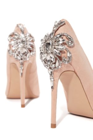 A pair of high-heeled shoes with a crystal brooch, perfect for a Quinceanera celebration