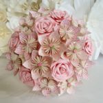 A beautiful Quinceanera floral design featuring a bouquet of pink and white flowers on a bed