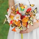 Quinceanera image: A woman in a white dress holding a bouquet of butterflies, a unique alternative to a flower bouquet.