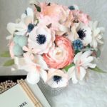 Quinceanera-themed flower bouquet with a book on a table