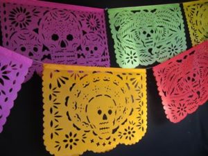 A group of colorful crochet Papel picado decorations hanging from a ceiling