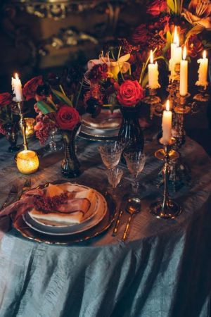 A Victorian themed Quinceanera centrepiece, featuring a dinner table adorned with candles and flowers.