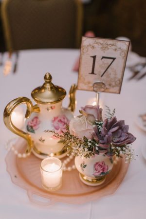 Victorian style Quinceanera party decorations, featuring a table with a tea pot and some candles