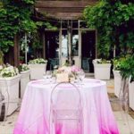 A Quinceanera table with a white and pink tablecloth