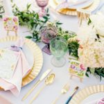 A beautifully set Quinceanera table with cut flowers and plates