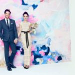 A man and woman standing next to each other at a Quinceanera celebration wearing J.Crew attire.