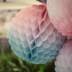 A beautiful arrangement of pink and blue tissue pom poms, perfect for a Quinceanera celebration or baby shower.