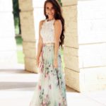 A woman in a floral Quinceanera dress posing for a picture with a floral and frill maxi skirt