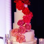 Quinceanera cake with floral design, a white cake adorned with red flowers on top