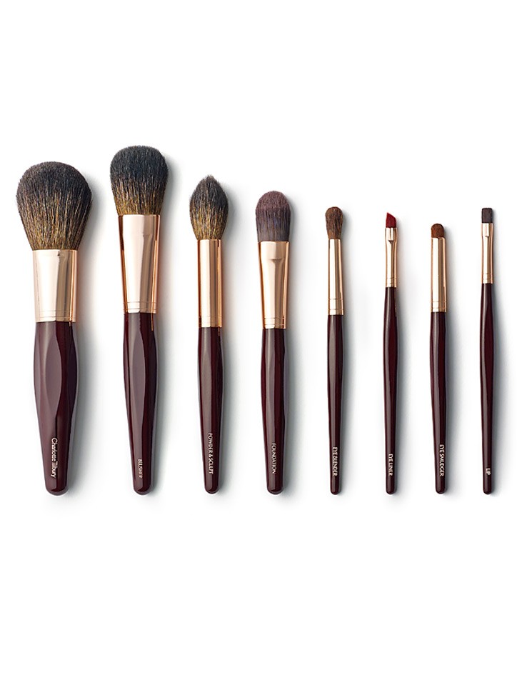 A row of Quinceanera makeup brushes including a Charlotte Tilbury bronzer brush and powder brush.