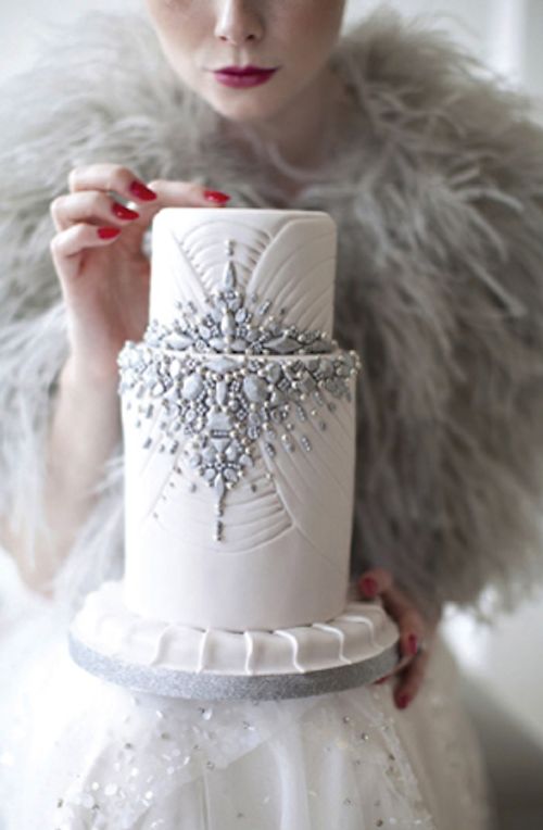 A woman in a white dress holding a white cake, with a luxurious and glamorous winter Quinceanera theme
