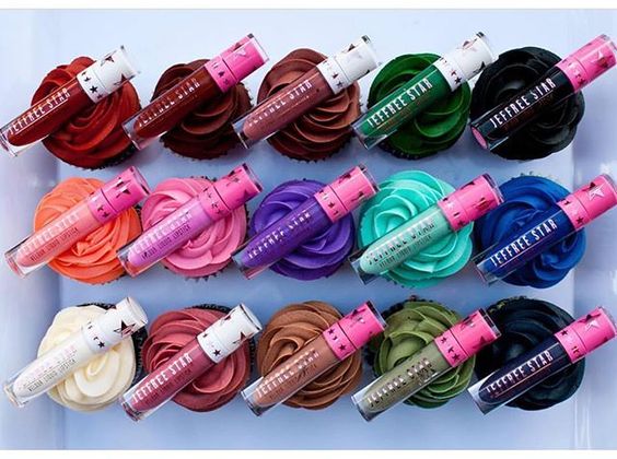 A Quinceanera themed image featuring plastic Jeffree Star Cosmetics and a box filled with lots of different colored cupcakes