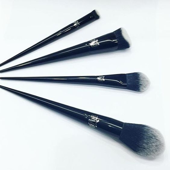 Quinceanera makeup brushes, a set of five brushes sitting on top of a white surface