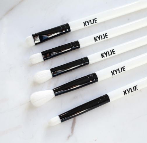 Five makeup brushes from Kylie Cosmetics displayed on a table for Quinceanera