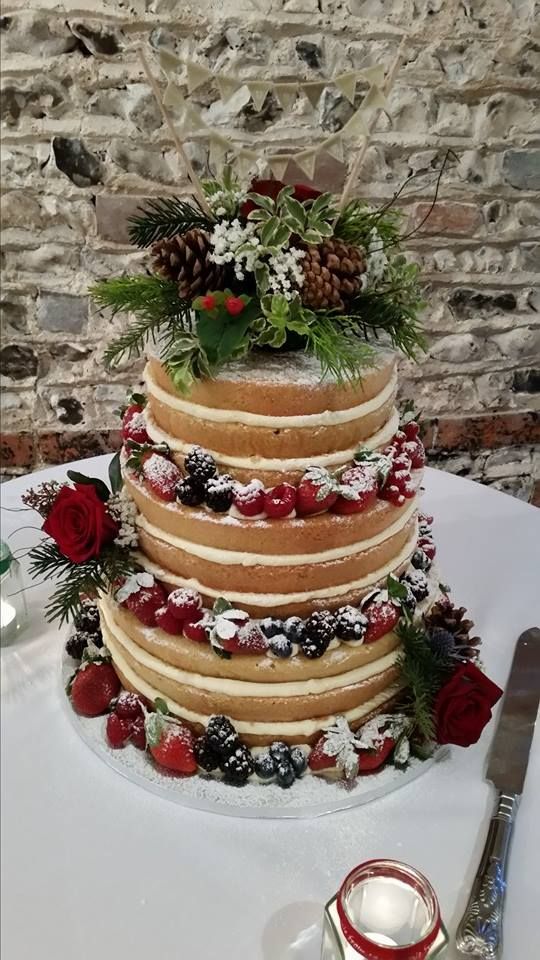 A Quinceanera cake with berries and pine cones