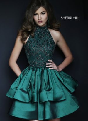 A fashion model in a green dress posing for a picture at a Quinceanera