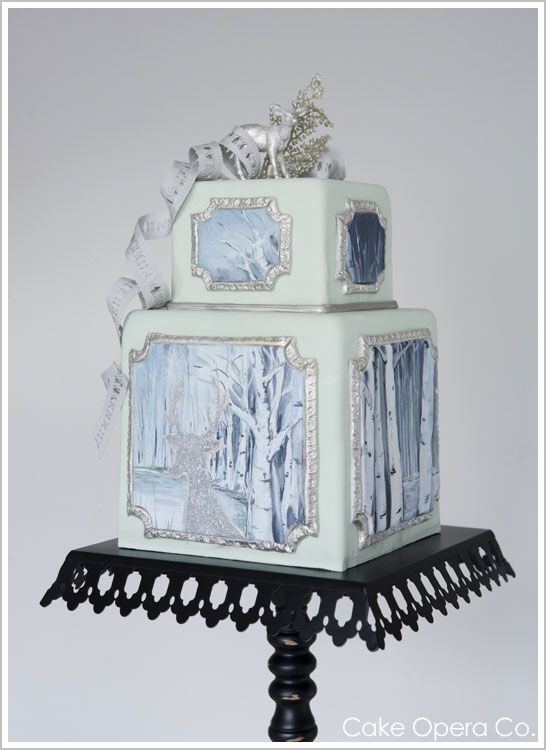 An elegant Quinceanera cake called Torte. It is a three-tiered cake with pictures on it, perfect for a winter celebration.