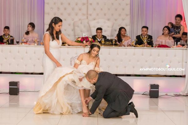 Bride Quinceañera and a man kneeling down to a woman in a Quinceanera dress