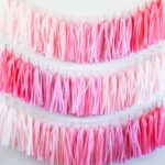 Quinceanera party decoration: a pink and white tasselled garland hanging on a wall