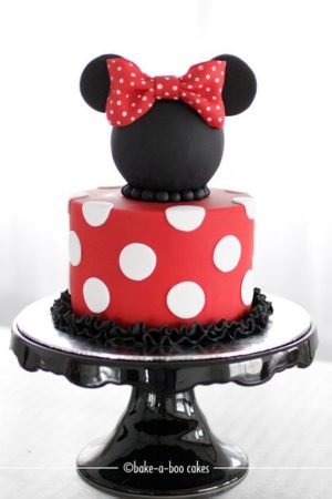 A Quinceanera-themed cake with a red and white design, adorned with a Minnie Mouse cake topper.