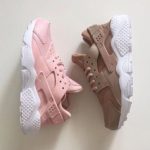 A pair of pink and brown Nike Huarache sneakers placed on a white surface, perfect for a Quinceanera celebration